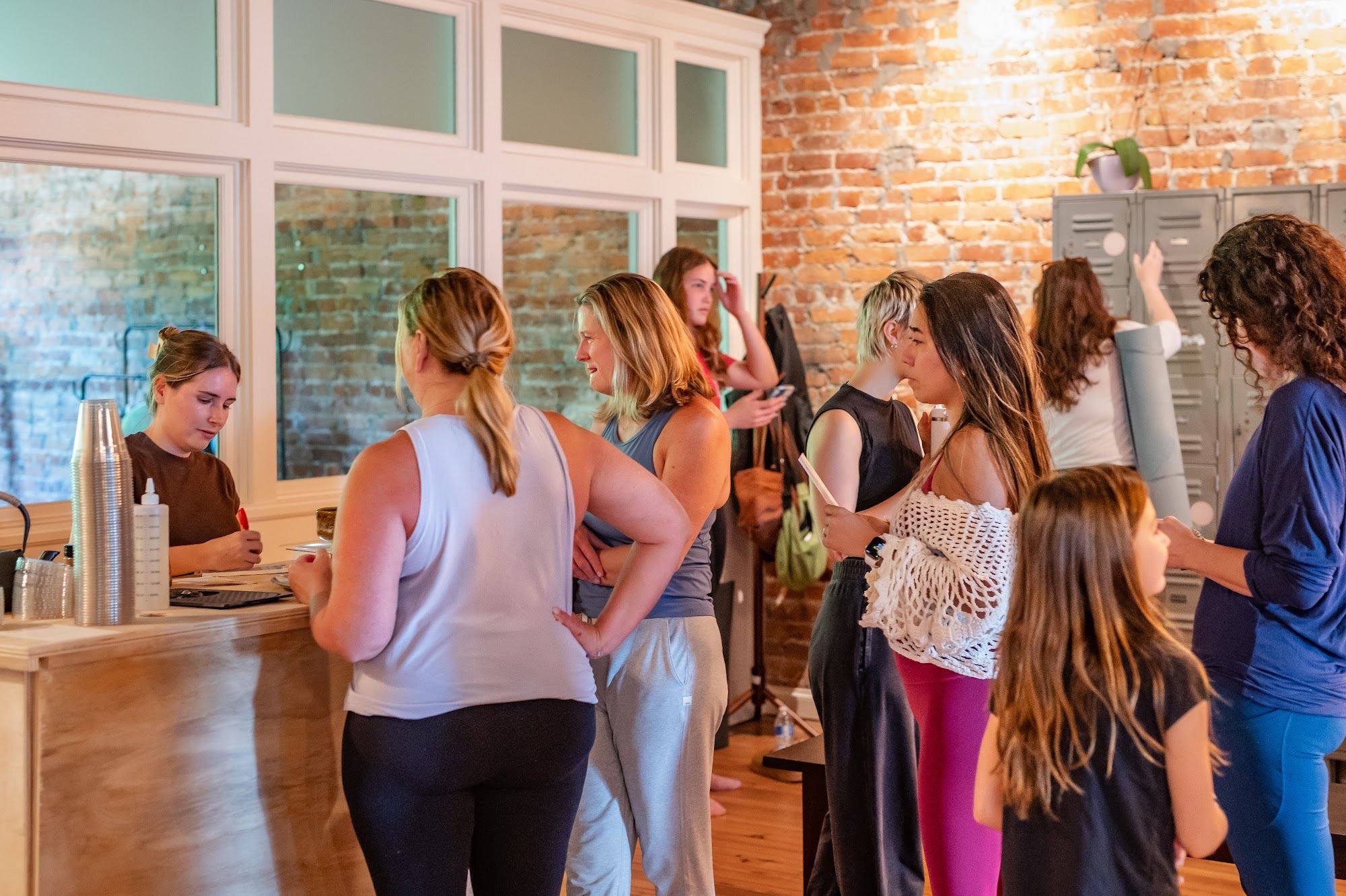 Students gathering and talking after an event at The Yoga Loft