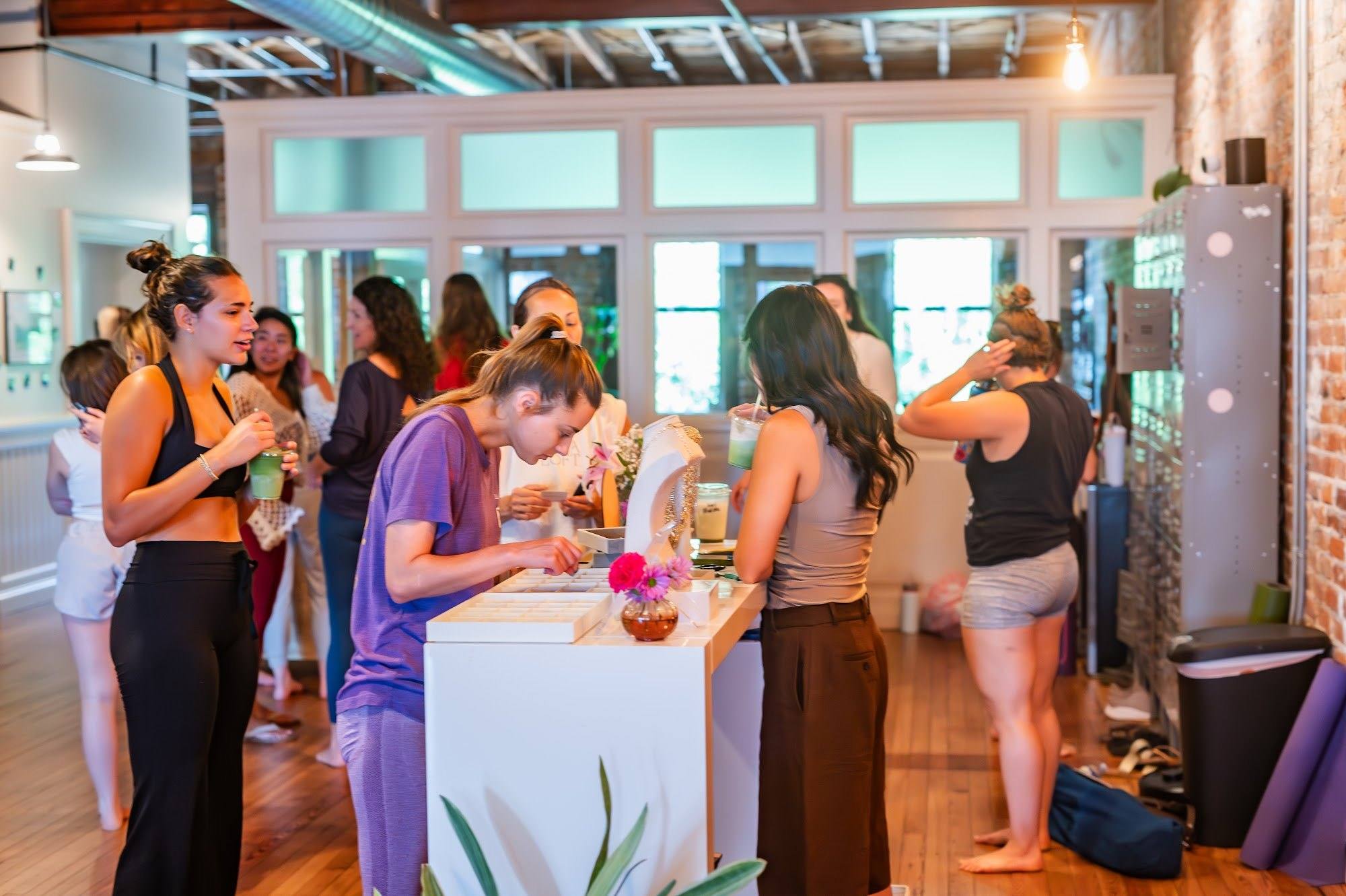 Students gathering and chatting in the lobby of The Yoga Loft after class